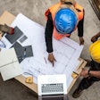 overhead view of workers looking at construction plans