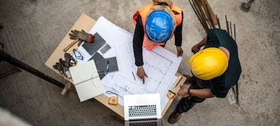 overhead view of workers looking at construction plans