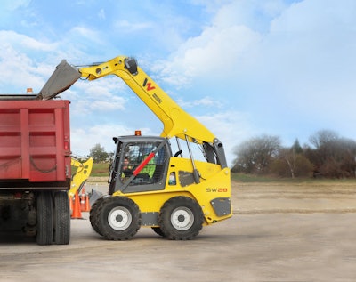 Wacker Neuson SW28 skid steer bucket raised over dump truck bed