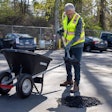 Microsoft co-founder Bill Gates fills a pothole with shovel and wheelbarrow with Modern Hydrogen asphalt