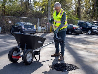 Microsoft co-founder Bill Gates fills a pothole with shovel and wheelbarrow with Modern Hydrogen asphalt