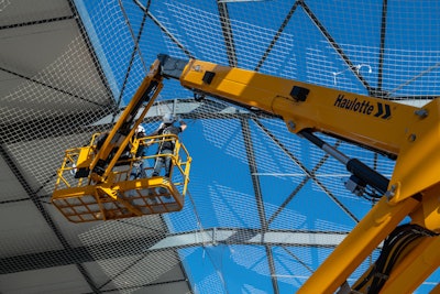 closer look at platform with workers on Haulotte HA61 RTJ Pro rough terrain articulated boom lift