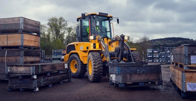 Volvo compact wheel loader carrying load on forks