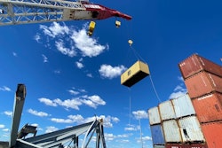 container being removed by crane from dali cargo ship trapped under baltimore key bridge wreckage