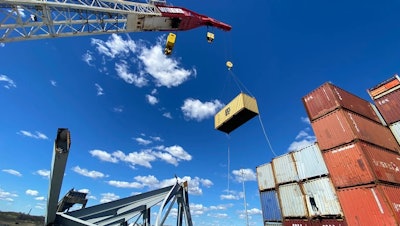 container being removed by crane from dali cargo ship trapped under baltimore key bridge wreckage