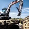 Bobcat E88 excavator lifting a pipe