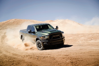 green 2024 Ram 2500 Heavy Duty Rebel kicking up dust in desert