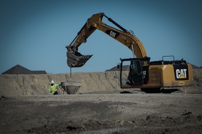 Cat excavator hoisting concrete