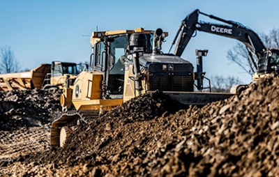 Deere dozer pushing dirt Deere excavator dumpt truck background