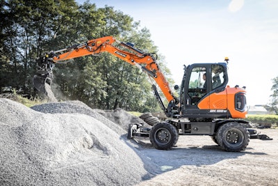 Develon DX100W-7 Wheeled Excavator dumping gravel on gravel pile