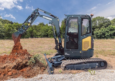 Hyundai HX27AZ compact excavator emptying bucket of dirt