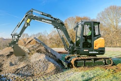 Hyundai HX55ACR compact excavator filling bucket with gravel