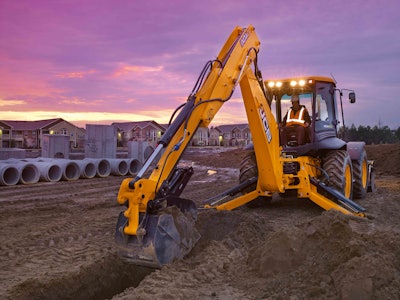 JCB 4CX backhoe digging with excavator end stabilizers extended