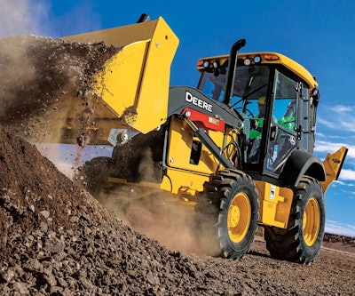 John Deere 320 P-Tier Backhoe pushing dirt up hill