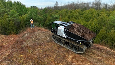 worker on dirt hill operates prinoth crawler carrier with remote control