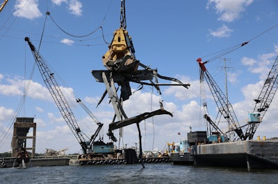 The 1,000-ton floating crane called 'Chessie' with hydraulic claw “Gus” hoist a 90-ton piece of wreckage June 7 from the Baltimore Port channel
