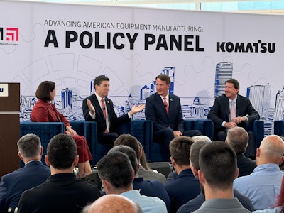 four people sitting on stage discussing policy