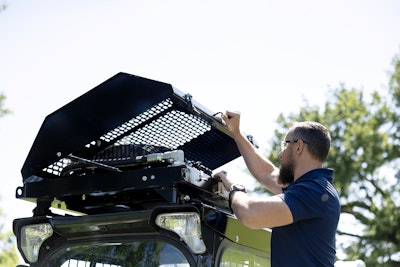 man lifting cover of diamond mowers' sk rooftop cooler