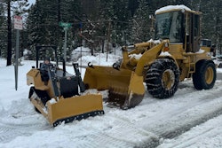 mini replica Cat D5 dozer with boy in seat beside large Cat wheel loader