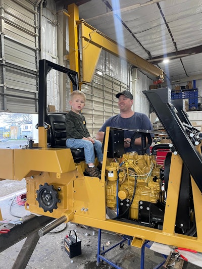 henry and father randy chrisman in unfinished D.5 mini dozer in shop