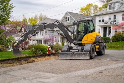 Mecalac MWR9 wheeled excavator digging utility trench roadside