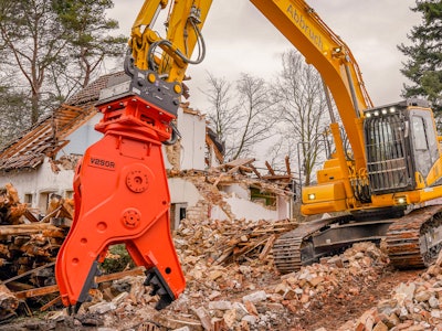 orange NPK V250R crusher pulverizer on excavator grabbing demolition debris