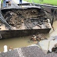 several people stand next to collapsed bridge in Kentucky