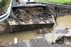 several people stand next to collapsed bridge in Kentucky