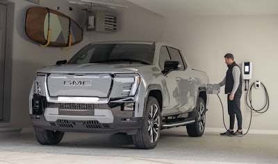 silver 2024 GMC Sierra Denali EV plugged in to charger