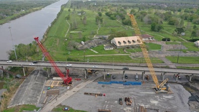 aerial shot of two cranes working on belle chasse bridge
