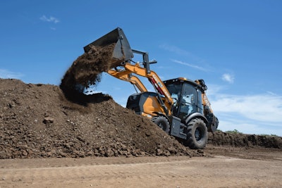 Case 580EV electric backhoe on dirt pile