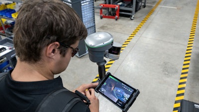 guy using GeoCue TrueView Go handheld 3D scanner and tablet in warehouse