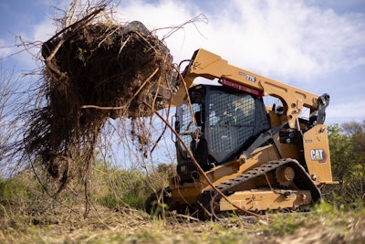 cat 275 CTL lifting brush on a jobsite