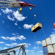 crane lifts shipping container off ship