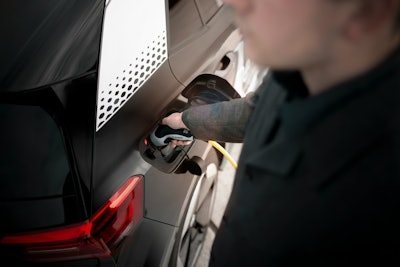 man holding charger in electric vehicle