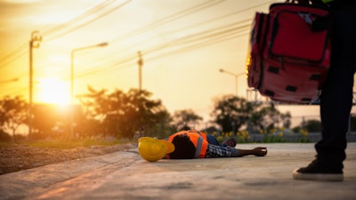 stock image of worker on ground in heat
