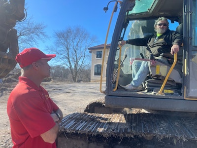 Greg Bair talks to an excavator operator on a jobsite