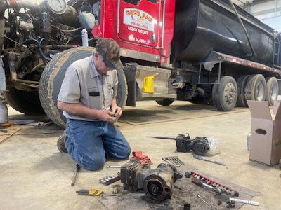 A mechanic works on a truck at Greg Bair Track Hoe Service