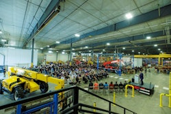 crowd of Manitou employees seated at Yankton South Dakota plant expansion ribbon cutting ceremony with Gehl and Manitou telehandlers