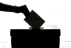 hand dropping ballot into ballot box