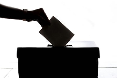 hand dropping ballot into ballot box