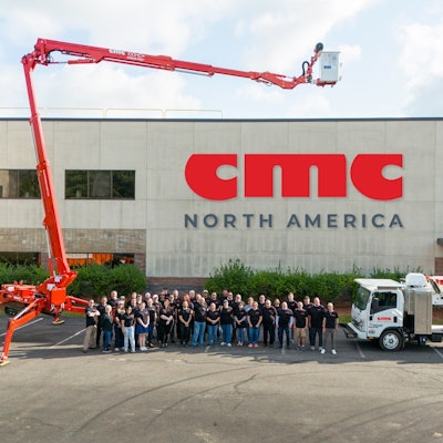 employees stand in front of new cmc north america building logo