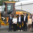executives and Prince Philip stand in from of a Volvo wheel loader