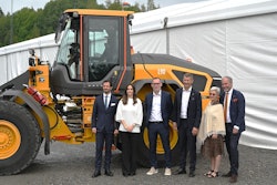executives and Prince Philip stand in from of a Volvo wheel loader