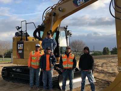 Buenas Brothers Construction owners next to a Cat excavator