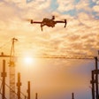 a DJI drone flies over a jobsite