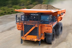 orange Hitachi mining truck hauling load of dirt