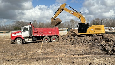 Cat excavator loading a dump truck on an EMi Construction site