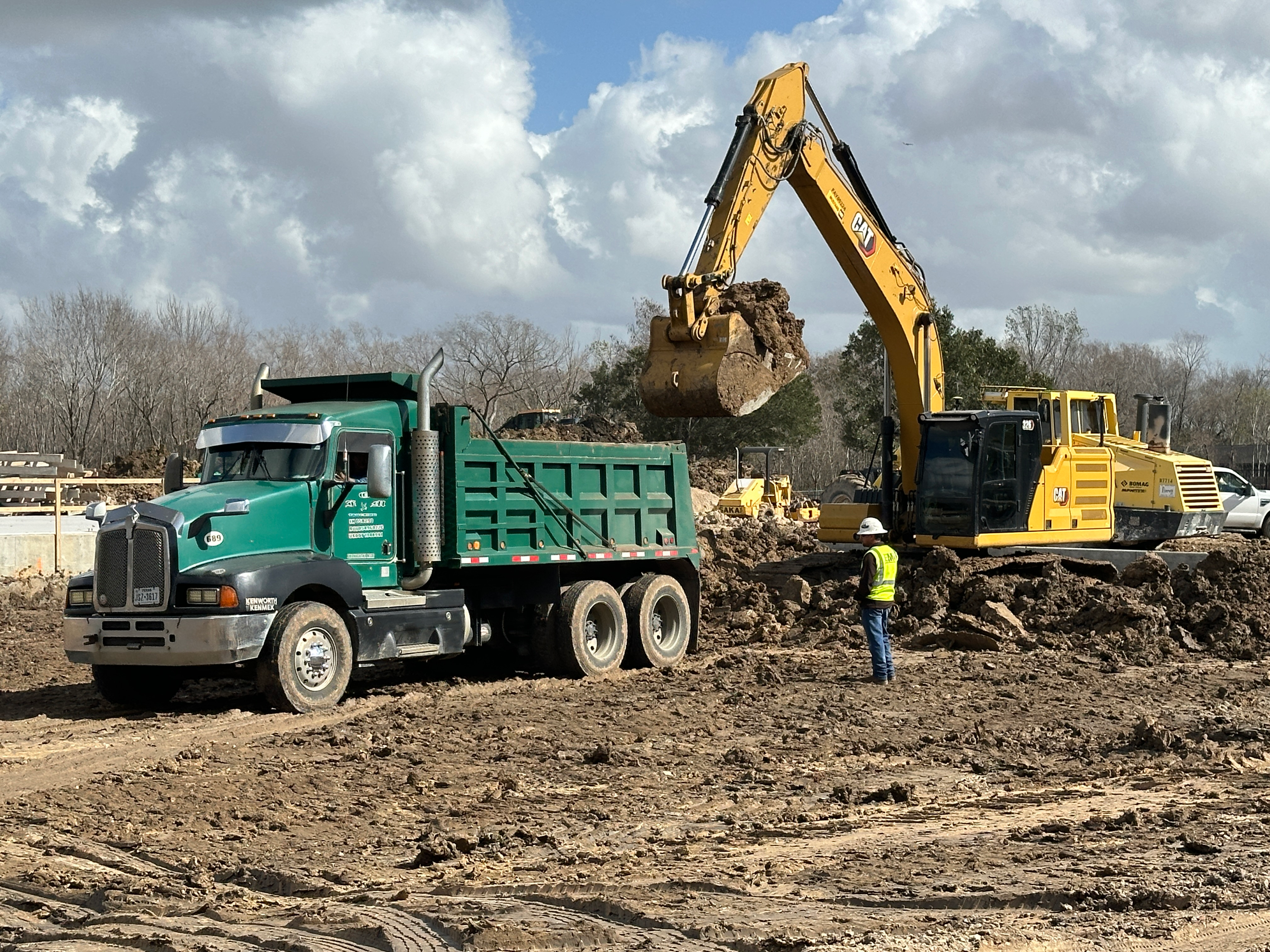 Excavator loading a dump truck at an EMi Construction site
