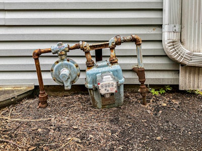 stock image rusty natural gas pipe and meter outside building